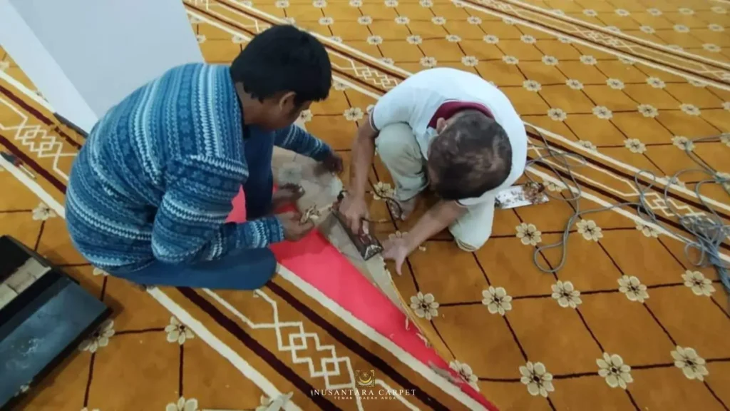 Pekerja memotong dan memasang karpet kuning bercorak bunga