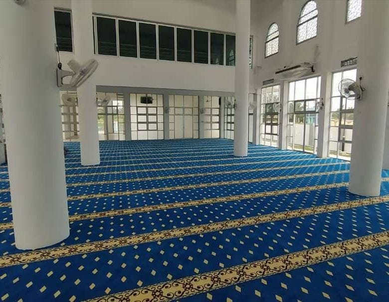 Pandangan sudut luas ke arah belakang dewan solat Masjid Jamek Al-Mansur memaparkan karpet saf minimalis biru terang