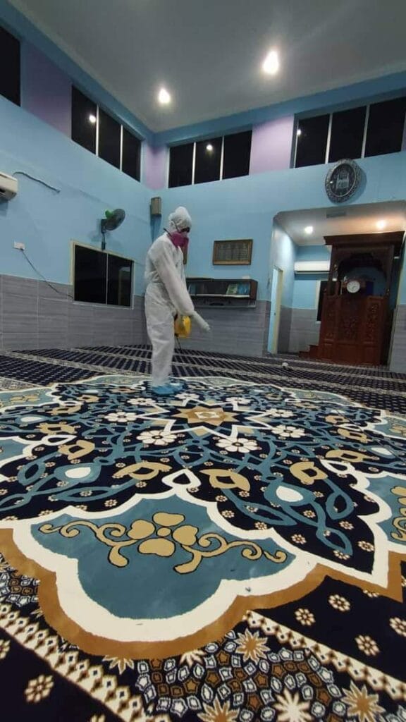 Pasukan Nusantara berpakaian PPE melakukan proses semburan sanitasi di atas karpet kustom baharu bercorak medallion di Masjid Jamek Al-Ridhuan semasa wabak covid berleluasa