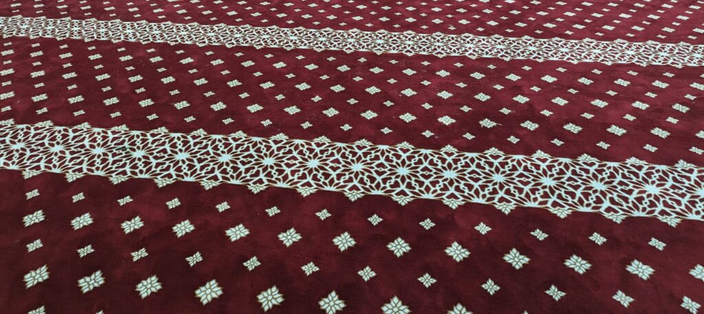 Karpet Masjid LKNP Pekan berlandaskan corak bunga geometri menaikkan seri suasana masjid.