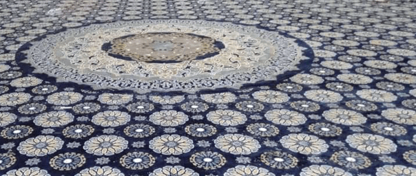 Pandangan dekat corak medallion pusat dan geometri floral pada karpet premium Masjid Daerah Barat Daya