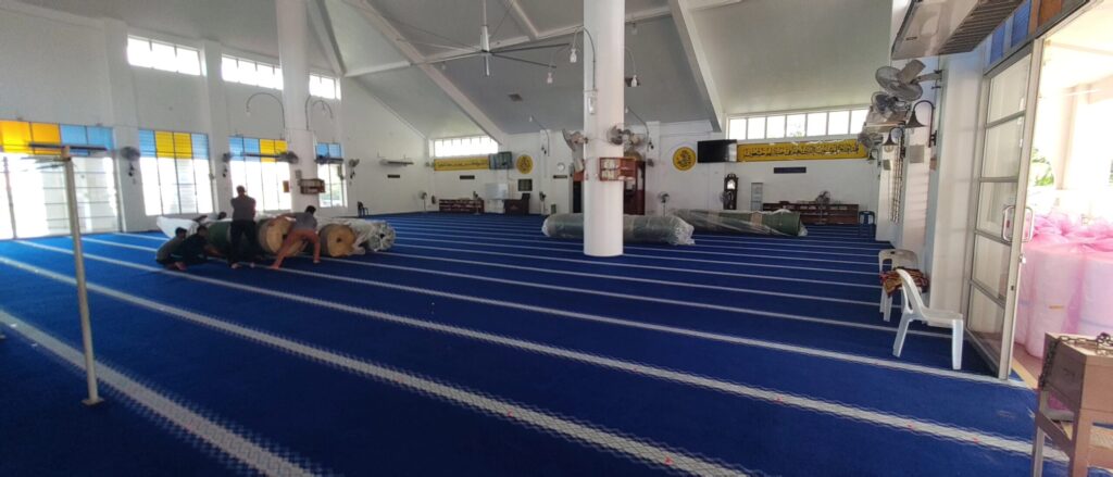 Proses persiapan dan pembentangan karpet masjid premium berwarna biru di Masjid Tunku Abdul Rahman Putra