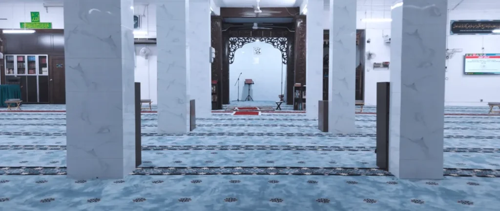 Memilih karpet masjid untuk ruang solat berpilar dengan lengkungan kayu berukir, Pemasangan karpet masjid dengan corak geometri Islamik di ruang solat Masjid Kg Kuantan, Klang.