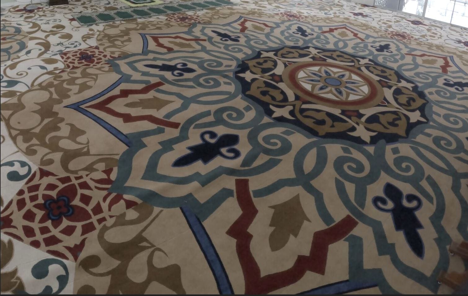 Pandangan dari sudut atas memaparkan perincian reka bentuk medallion gergasi bercorak arabes pada karpet masjid kustom di Masjid At-Taqwa