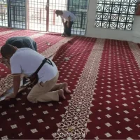 Proses pemasangan karpet masjid dengan corak geometri Islamik di Masjid At Taqwa Padang Tembak.